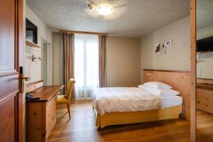 a hotel room with a bed and a desk at Seehof Reduit in Davos