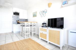 a kitchen with a flat screen tv and a counter at Le balcon de Jersey - face à la mer in Saint-Jean-de-la-Rivière +8 photos