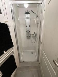 a shower with a glass door in a bathroom at Appart Leonard - Loger à côté de Paris et Disneyland in Romilly-sur-Seine