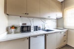 a kitchen with white cabinets and a microwave at Sea View Studio Flat Near Beylerbeyi Palace in Istanbul