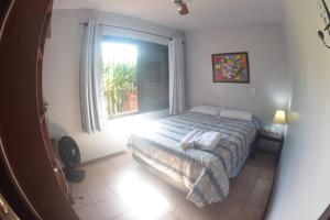 sypialnia z łóżkiem i oknem w obiekcie Pousada Quintal ! w mieście Xangri-lá