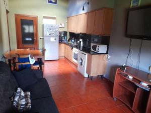 cocina con sofá, mesa y nevera en Apartament Gran Pirineu, en Montferrer