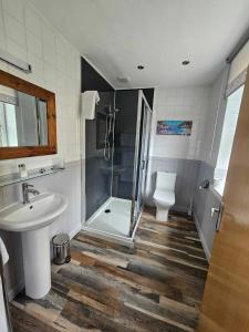 a bathroom with a shower and a sink and a toilet at Park Lodge Hotel in Tobermory