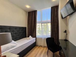 ein Hotelzimmer mit einem Bett und einem Fenster in der Unterkunft AM HOTEL WELLNESS **** in Rimavská Sobota