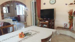 sala de estar con mesa y TV en Villa Sabrina, en Castro dei Volsci