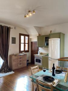 a kitchen with green cabinets and a table with chairs at Delfi's cozy maisonette in Delphi