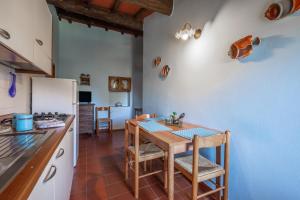 a kitchen with a table and a refrigerator at La pieve - Gerani in Pereta
