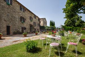 a group of chairs and tables in front of a building at La pieve - Gerani in Pereta