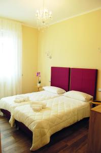a bedroom with a large bed with a red headboard at B&B dei Gemelli in Bareggio