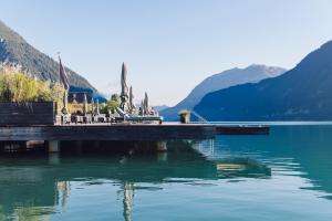 a dock on a lake with mountains in the background at Seehotel Einwaller - adults only in Pertisau