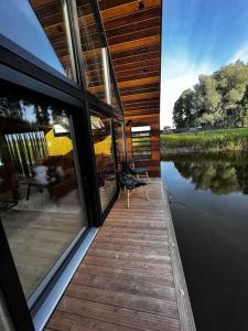 a house with a wooden deck and a view of the water at Feel the breeze - cozy luxury in Elva