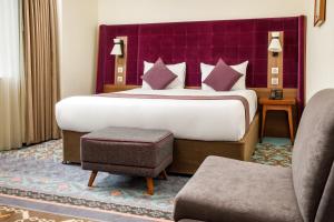Cette chambre d'hôtel comprend un grand lit avec une tête de lit violette. dans l'établissement Mercure London Bridge, à Londres