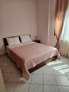 sypialnia z łóżkiem z różowym kocem w obiekcie Pallantza Estate Trikala w mieście Tríkala