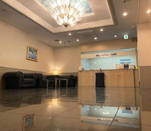 a lobby with a waiting room with a chandelier at HOTEL THE NEXT KANKU in Sennan