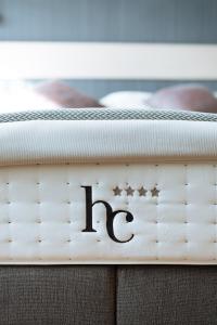 a bed with the hc sign on it at Cosmopolite Hotel Nieuwpoort-Bad in Nieuwpoort