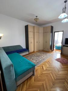 een slaapkamer met twee bedden en een houten vloer bij Balcescu Alina's apartament in Sibiu