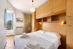 una camera con un grande letto con testiera in legno di Appartamento Celsi a Moneglia