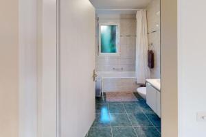 a bathroom with a tub and a toilet and a sink at Casa delle Vigne: Giardino, pergola e vista lago in Minusio +49 photos
