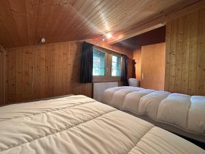 a row of beds in a room with wooden walls at Chalet Rose Bay in Leysin