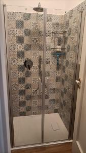 La salle de bains est pourvue d'une douche avec une porte en verre. dans l'établissement Amelia's Home tra Etna e Taormina with pool, à Riposto
