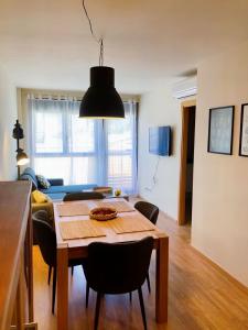 Apartament dúplex amb vistes al Pirineu català في كول دي نارجو: طاولة طعام مع كراسي وضوء أسود