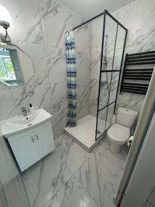 biała łazienka z toaletą i prysznicem w obiekcie WAW Pokoje Ursynów w Warszawie