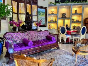 a living room with a purple couch and some chairs at Casa Madre Tierra in Valle de Anton