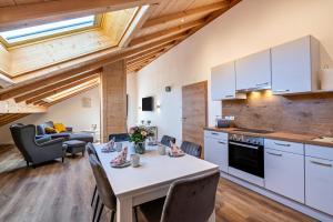 a kitchen and living room with a table and chairs at Wohnung Brauneck in Gaißach