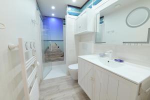 Baño blanco con aseo y lavamanos en exceptionnelle maison de charme à 50m du port et de sa plage, en Cancale