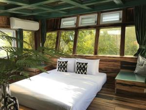 a bedroom with a large white bed and windows at 秘密花園設計villas Sun Moon Lake Secret Garden Design Villas in Yuchi