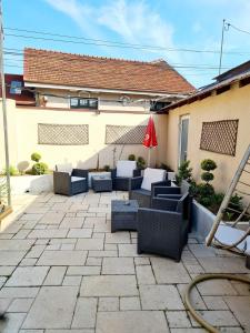 un patio con sofás y una sombrilla en Laci lak modern apartment, en Oradea