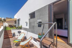 balkon domu z 2 krzesłami i stołem w obiekcie Villa Al Alba w mieście Tafira Baja