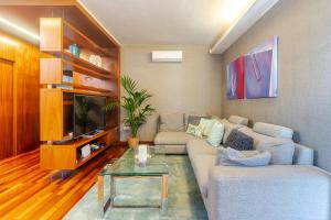 a living room with a couch and a tv at Villa Al Alba in Tafira Baja