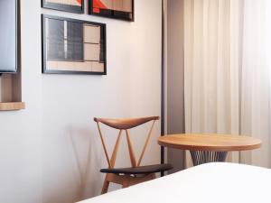 stół i 2 krzesła w pokoju w obiekcie Le Méridien Etoile w Paryżu
