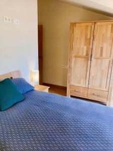 Apartament dúplex amb vistes al Pirineu català في كول دي نارجو: غرفة نوم بسرير ازرق وخزانة خشبية
