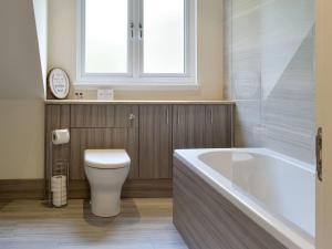 La salle de bains est pourvue de toilettes, d'une baignoire et d'une fenêtre. dans l'établissement Estate Houses at Carberry Tower, à Édimbourg