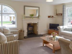 ein Wohnzimmer mit einem Sofa und einem Kamin in der Unterkunft Estate Houses at Carberry Tower in Edinburgh