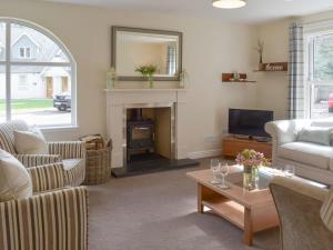 a living room with a couch and a fireplace at Estate Houses at Carberry Tower in Edinburgh