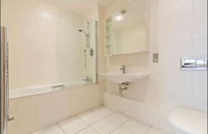 a white bathroom with a sink and a shower at Spacious Room with Relaxing View in Dublin