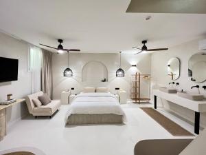 a white bedroom with a large bed and a chair at Superb Apartment Palais Royal Louvre Museum in Paris
