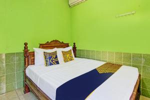 um quarto com uma cama grande e paredes verdes em SPOT ON 93029 Pondok Wisata Sabar Menanti 2 em Bantul