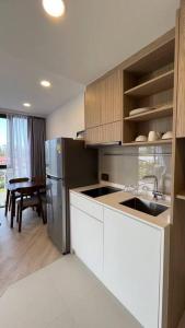 a kitchen with a stainless steel refrigerator and a table at Laguna Sky Park Corner 1 Bedroom in Bang Tao Beach