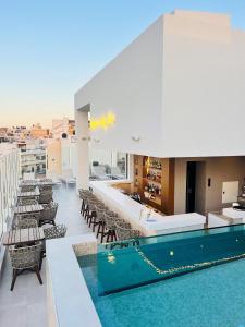 伊拉克利翁鎮的住宿－Ethereal White Resort Hotel & Spa，一座带椅子的建筑屋顶上的游泳池