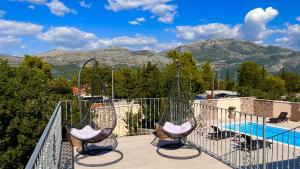 a balcony with two swings and a swimming pool at Villa Dalma in Čilipi