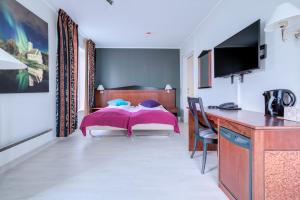 a bedroom with a bed and a desk at Melbu Hotell in Melbu