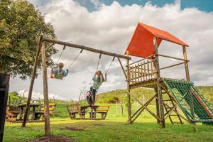 SwanepoelskraalにあるAfriCamps Addoの公園内のブランコで遊ぶ子供2名