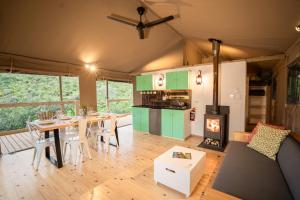 sala de estar con mesa de comedor y chimenea en AfriCamps Addo en Swanepoelskraal