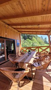 a table and chairs on a porch of a cabin at DOMEK NA GÓRACH z JACUZZI I SAUNĄ in Nowy Sącz