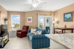 a living room with a blue couch and two chairs at Grande Caribbean 326 in Orange Beach