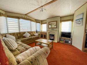 a living room with a couch and a table at Wonderful 8 Berth Caravan At Seawick Holiday Park In Clacton-on-sea Ref 27077r in Clacton-on-Sea